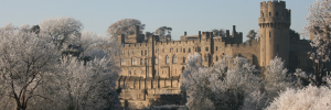 View of Warwick Castle over frost-covered trees